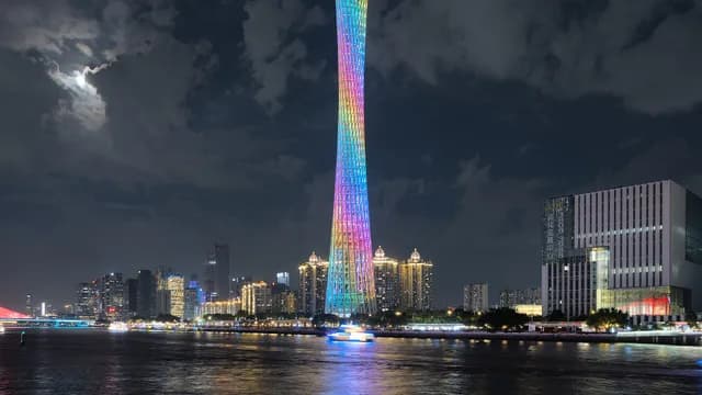 Canton Tower illuminated beside the Pearl River at night